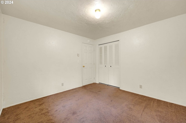 empty room with carpet and a textured ceiling