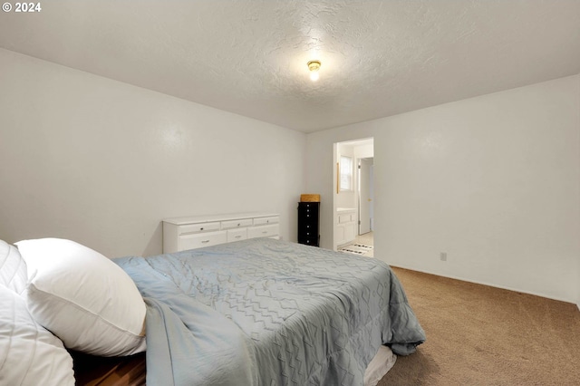 bedroom featuring carpet, a textured ceiling, and ensuite bath