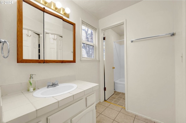 bathroom featuring tile patterned floors, shower / washtub combination, and vanity