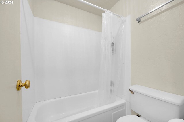 bathroom with shower / bath combo and toilet