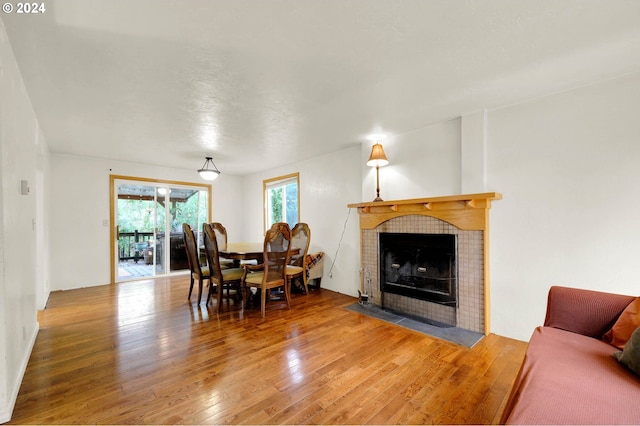 living room with a tile fireplace and wood-type flooring