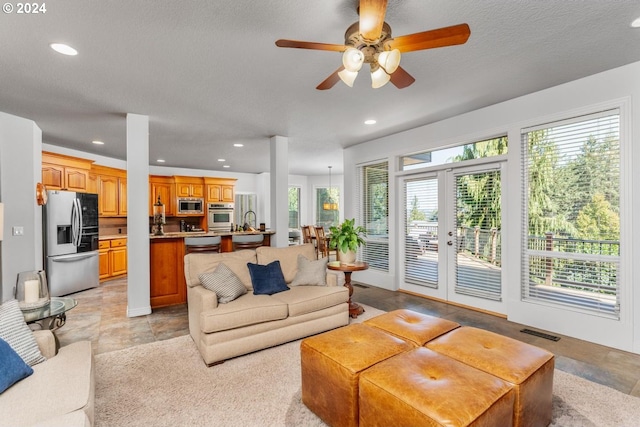 living area featuring recessed lighting, visible vents, and a healthy amount of sunlight