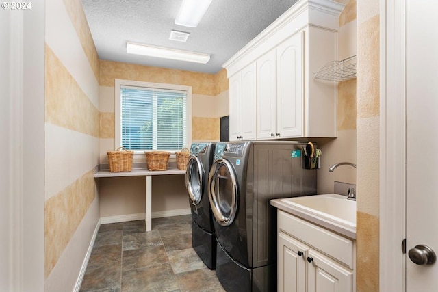 laundry room with a textured ceiling, washing machine and dryer, a sink, visible vents, and cabinet space