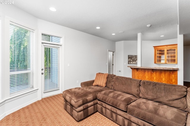 living room featuring light carpet, a textured ceiling, and recessed lighting