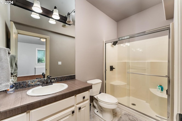 bathroom with a stall shower, tile patterned flooring, vanity, and toilet