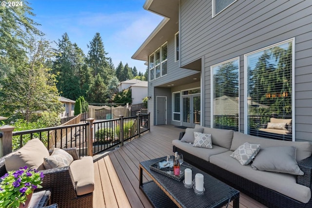 deck featuring french doors, fence, and an outdoor living space