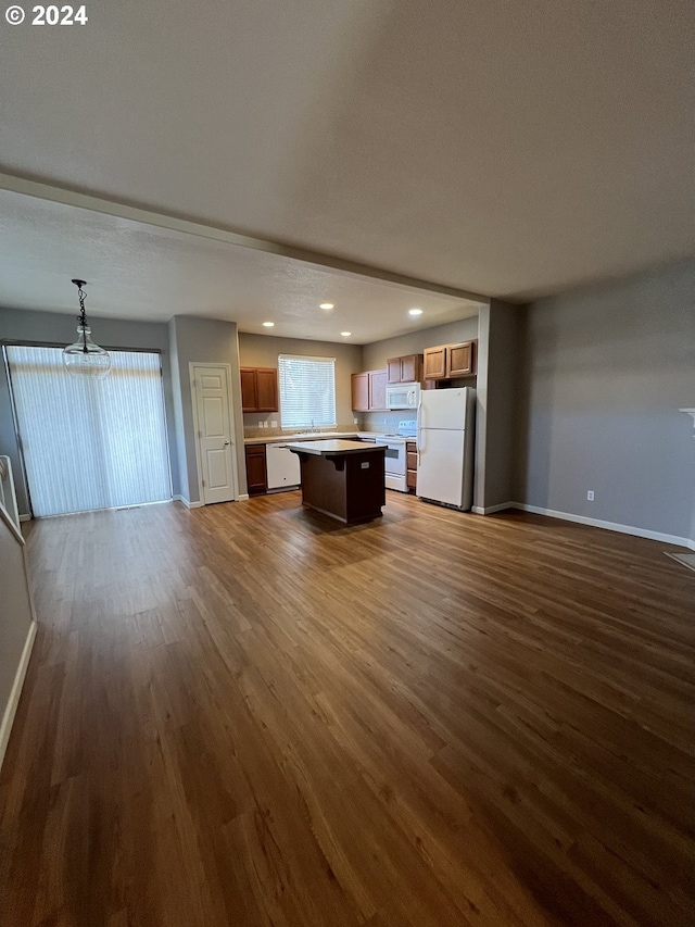 unfurnished living room featuring dark wood-type flooring and an inviting chandelier