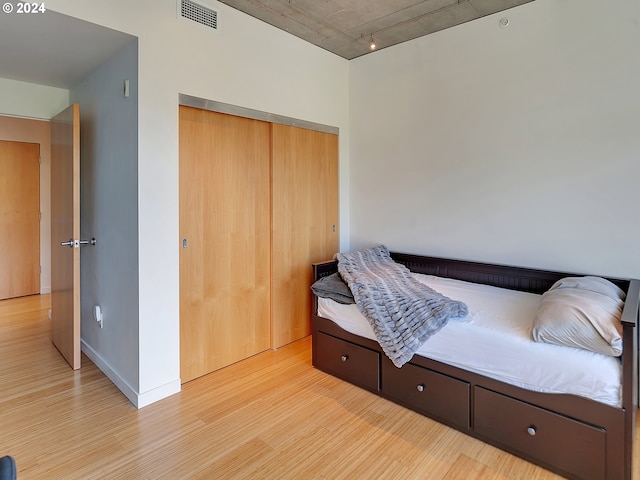 bedroom with light hardwood / wood-style flooring and a closet