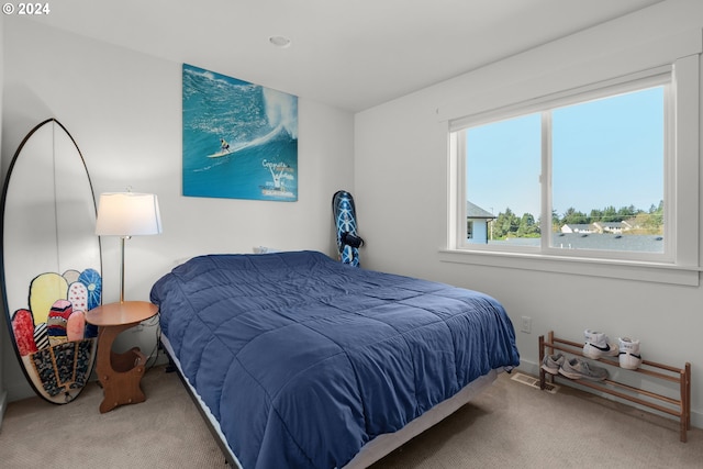 carpeted bedroom featuring a water view