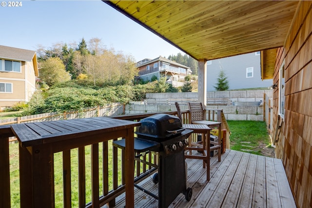 deck with a grill and a lawn