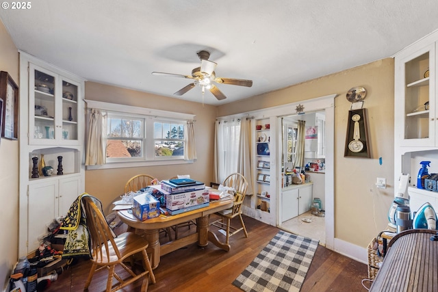 dining space with dark wood-type flooring and ceiling fan