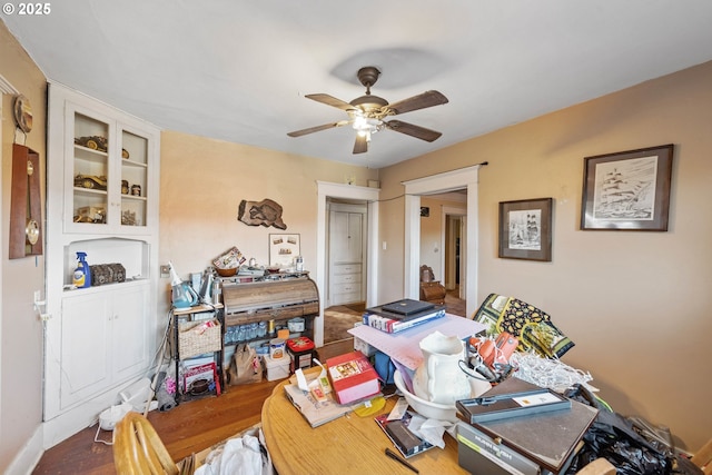 office space with built in features, hardwood / wood-style floors, and ceiling fan