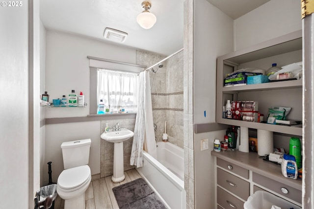 full bathroom with sink, hardwood / wood-style floors, toilet, and shower / tub combo