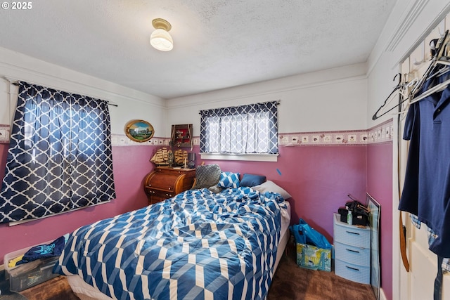 bedroom featuring carpet flooring and a textured ceiling