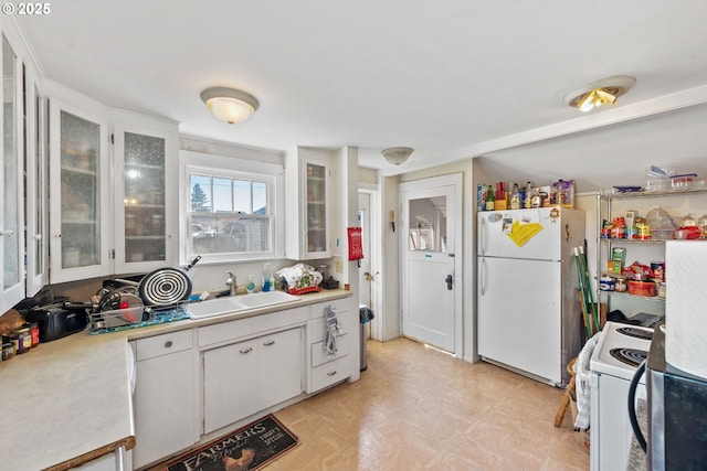 kitchen with sink, white appliances, and white cabinets