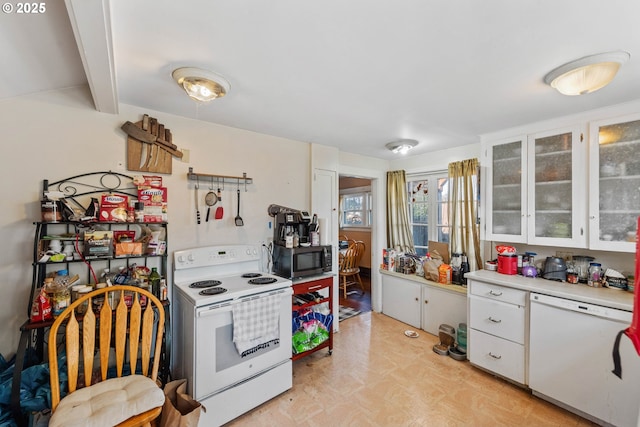 kitchen with white cabinetry, white appliances, and beamed ceiling