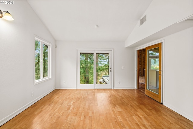 bedroom with french doors, light hardwood / wood-style flooring, and vaulted ceiling