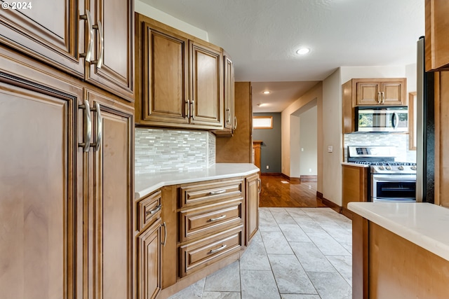 kitchen with tasteful backsplash and appliances with stainless steel finishes