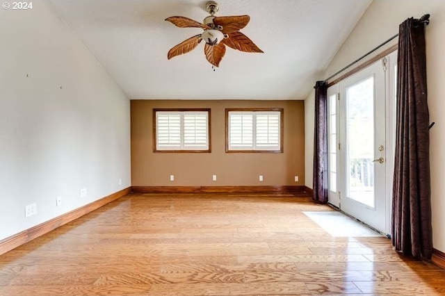 spare room featuring ceiling fan, light hardwood / wood-style flooring, a healthy amount of sunlight, and vaulted ceiling