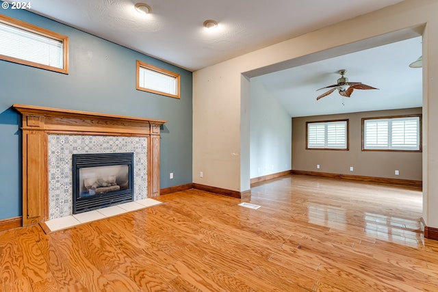 unfurnished living room with a fireplace, light hardwood / wood-style flooring, and ceiling fan