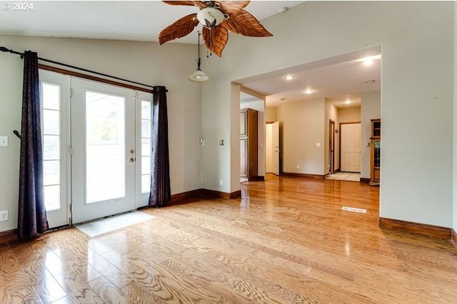 spare room with vaulted ceiling, ceiling fan, and light wood-type flooring