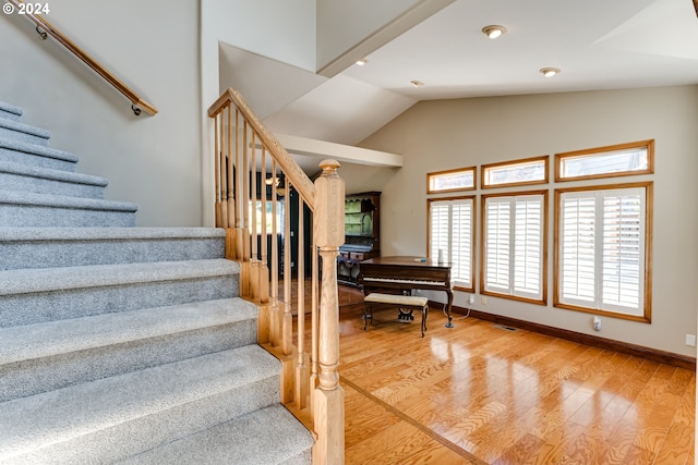 staircase featuring hardwood / wood-style floors and vaulted ceiling