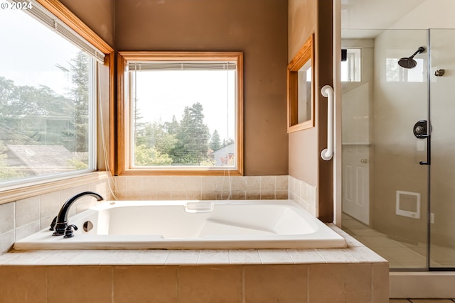 bathroom featuring independent shower and bath and a healthy amount of sunlight