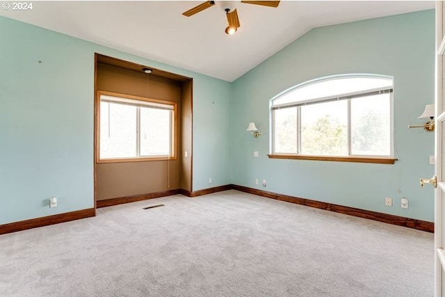 unfurnished room with vaulted ceiling, light colored carpet, and ceiling fan