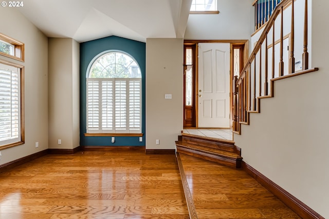 entrance foyer with lofted ceiling and light hardwood / wood-style flooring