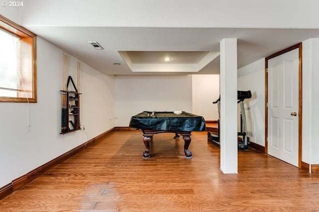 recreation room featuring a raised ceiling, light wood-type flooring, and billiards