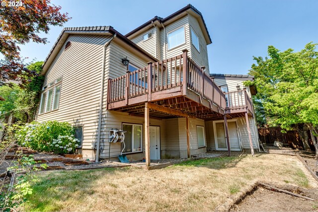 rear view of house with a wooden deck and a yard