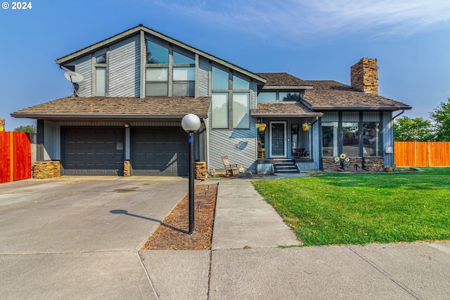 view of front of property with a garage and a front lawn