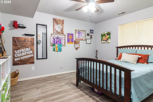 bedroom featuring hardwood / wood-style floors, a textured ceiling, and ceiling fan