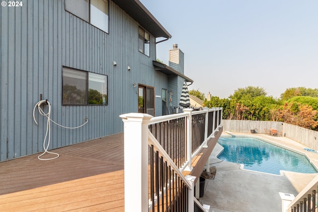 view of pool with a wooden deck and a patio