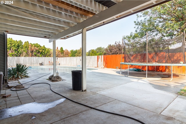 view of patio / terrace with an empty pool and a trampoline