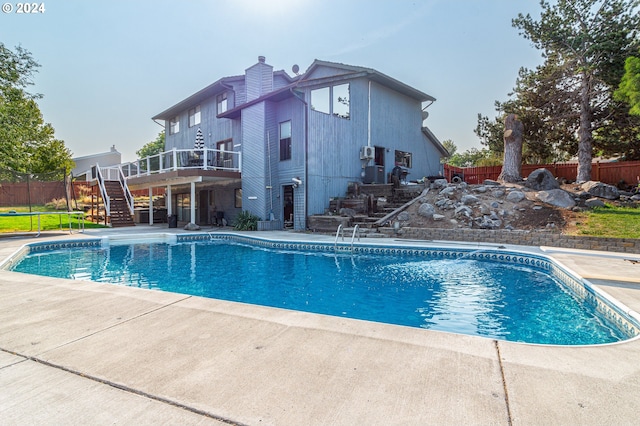 view of pool with a wooden deck and a patio