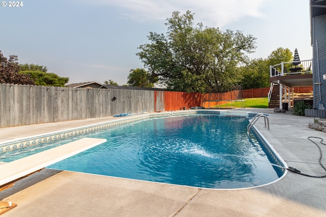 view of pool featuring a diving board and a patio