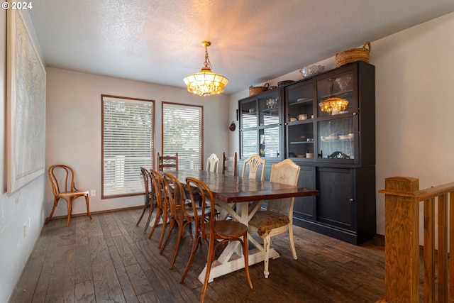 dining area featuring a chandelier, a textured ceiling, and dark hardwood / wood-style flooring