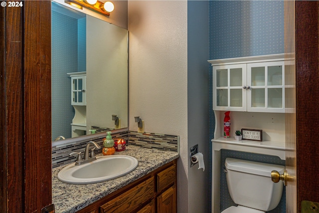 bathroom with vanity, toilet, and backsplash