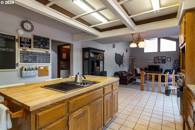 kitchen featuring wooden counters, beamed ceiling, light tile patterned flooring, pendant lighting, and a chandelier