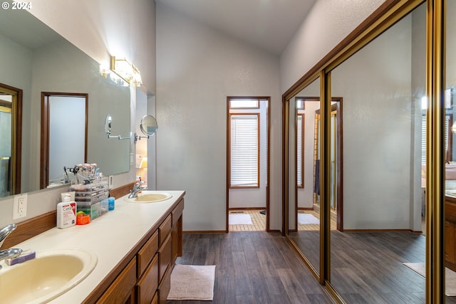 bathroom with vanity, lofted ceiling, and hardwood / wood-style floors