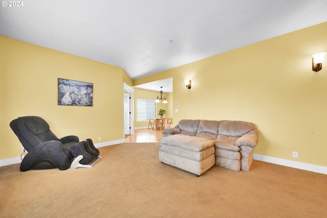 carpeted living room featuring an inviting chandelier