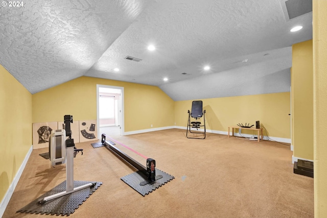 exercise area with light colored carpet, vaulted ceiling, and a textured ceiling