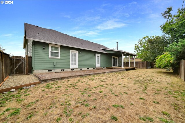 back of house featuring central AC, a deck, and a lawn