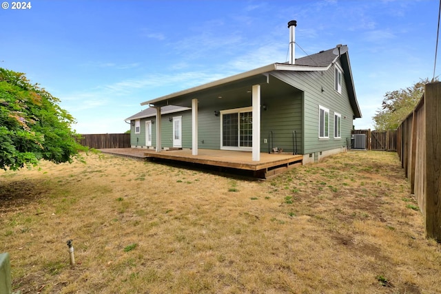 back of property with central AC unit, a lawn, and a deck