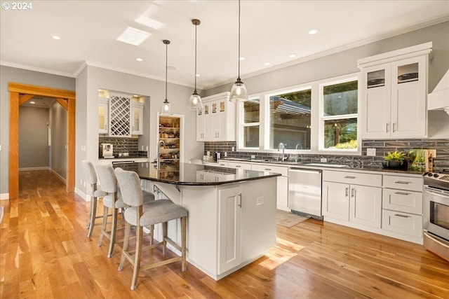 kitchen featuring white cabinets, stainless steel appliances, pendant lighting, and a center island