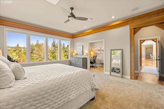 bedroom featuring ceiling fan, multiple windows, and light carpet