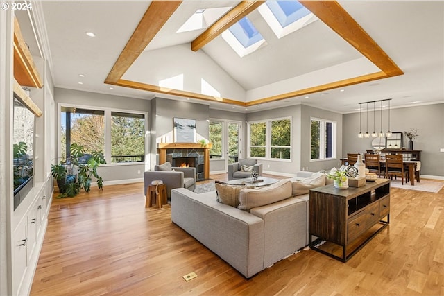 sunroom featuring a fireplace and vaulted ceiling with skylight