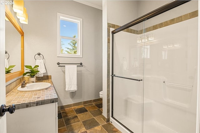 bathroom featuring toilet, a shower with door, crown molding, and vanity