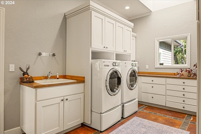 clothes washing area with cabinets, independent washer and dryer, and sink